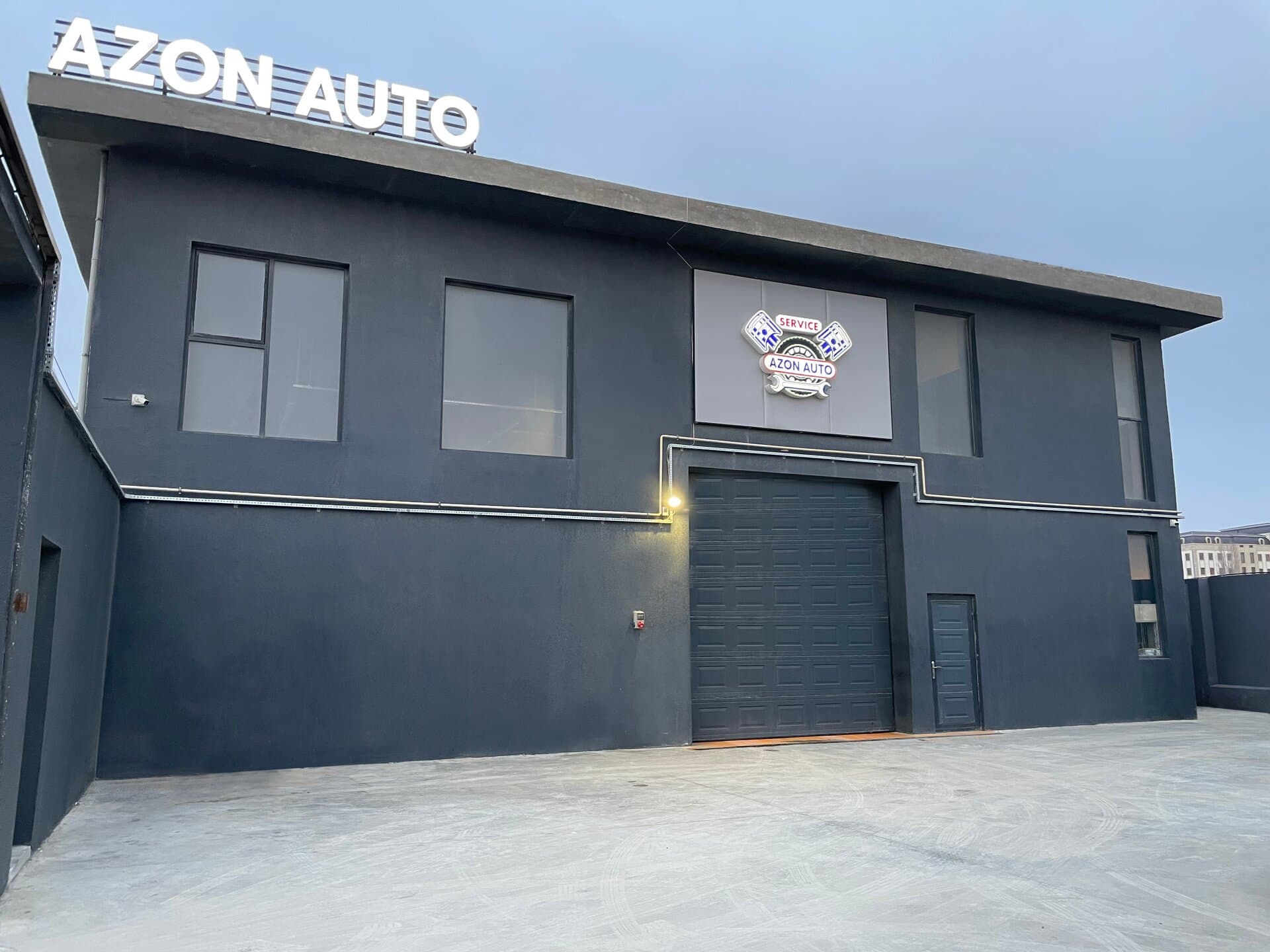 AzonAuto servisinin binası: damında AZON AUTO lövhəsi, qarajın giriş qapısı, Bakı