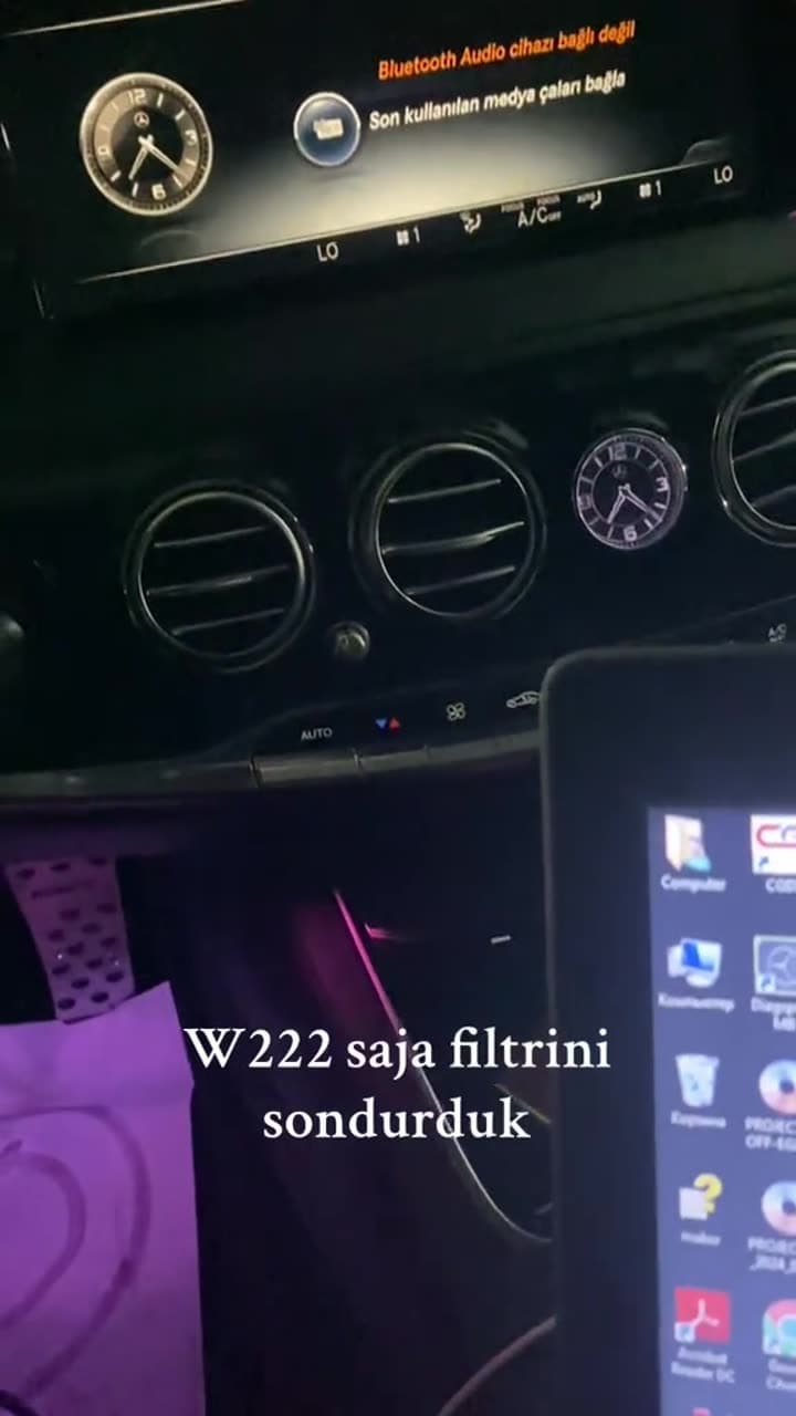 Mercedes S-Class (W222) salonunda noutbuk qoşulub, sonra panel göstərilir. Videonun yazısı: W222 saja filtrini söndürdük.